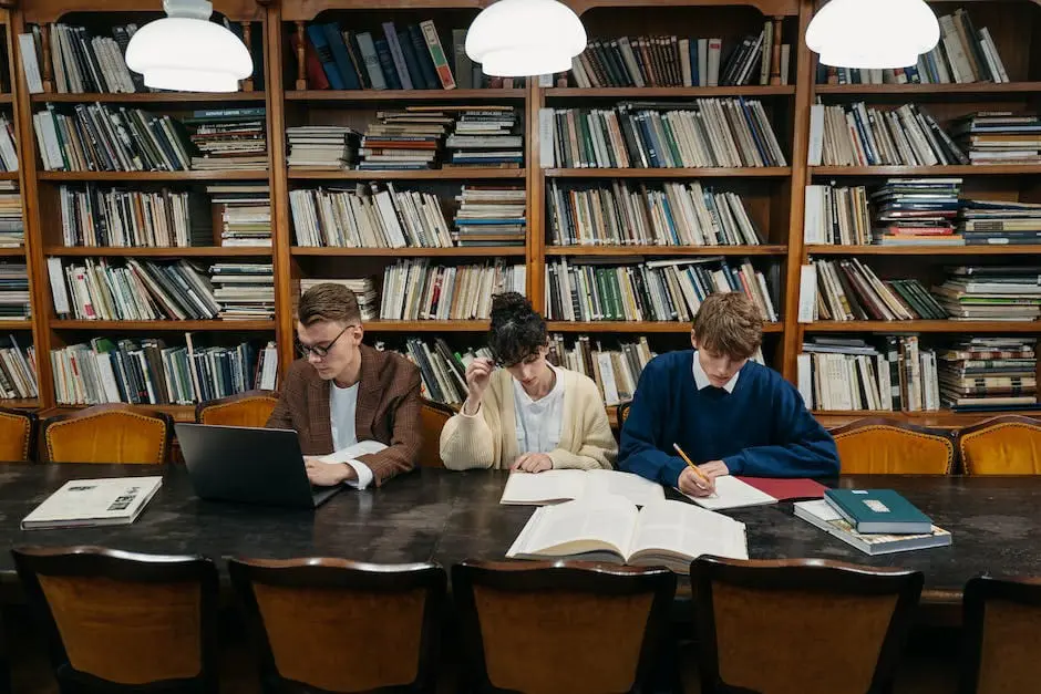 A group of students studying together with books and laptops.