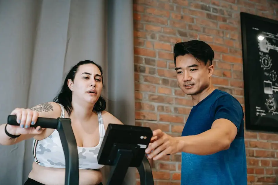 A person lifting weights in a gym with a personal trainer spotting them.